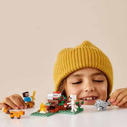 Child enjoying LEGO® Minecraft The Taiga Adventure Set 21162, featuring Steve, a fox, and other characters in a snowy scene.
