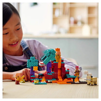 Girl playing with LEGO® Minecraft The Warped Forest set, featuring Huntress and colorful blocks in an exciting scene.
