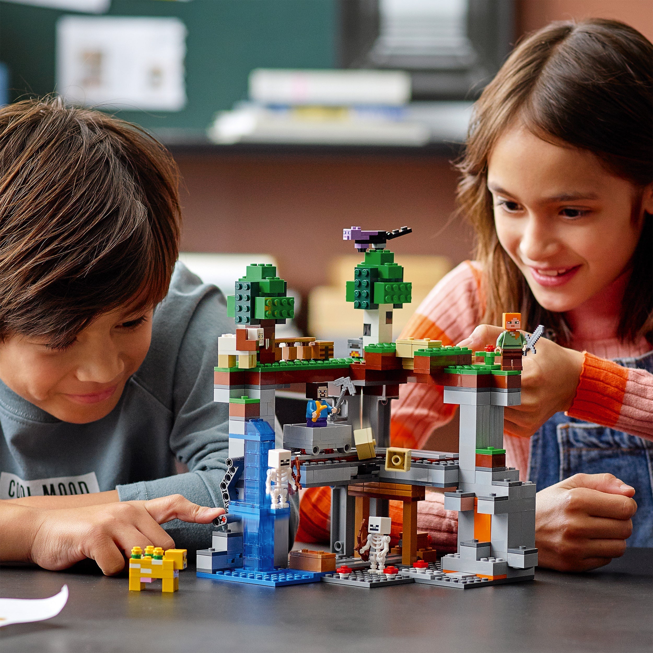 Kids play with LEGO® Minecraft The First Adventure Set 21169, featuring colorful characters and a vibrant Minecraft environment.