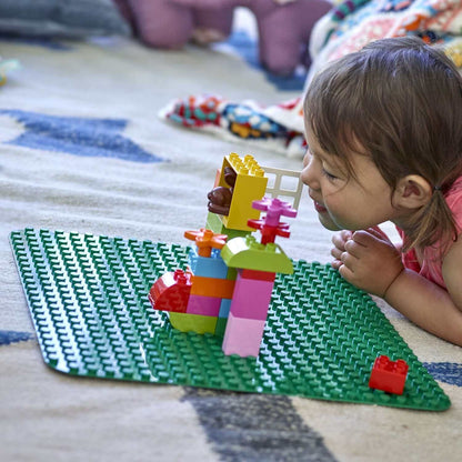 Child playing on LEGO® DUPLO Large Green Building Plate 2304, creating colorful structures and enjoying imaginative play.