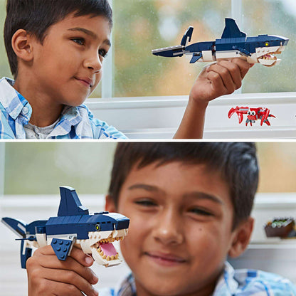 Boy holds LEGO Creator 3in1 shark model, showcasing creativity with deep sea creatures set 31088.