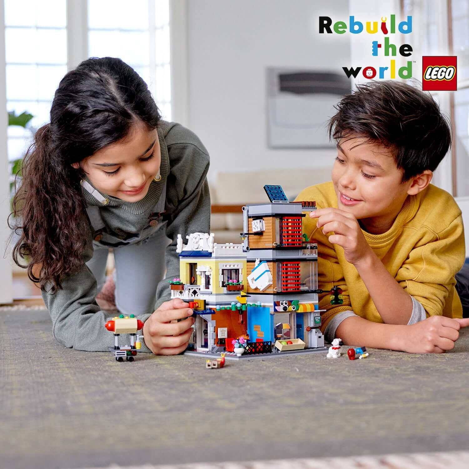 Kids building LEGO Creator 3in1 Townhouse Pet Shop & Café 31097, showcasing creativity and fun in a vibrant setting.