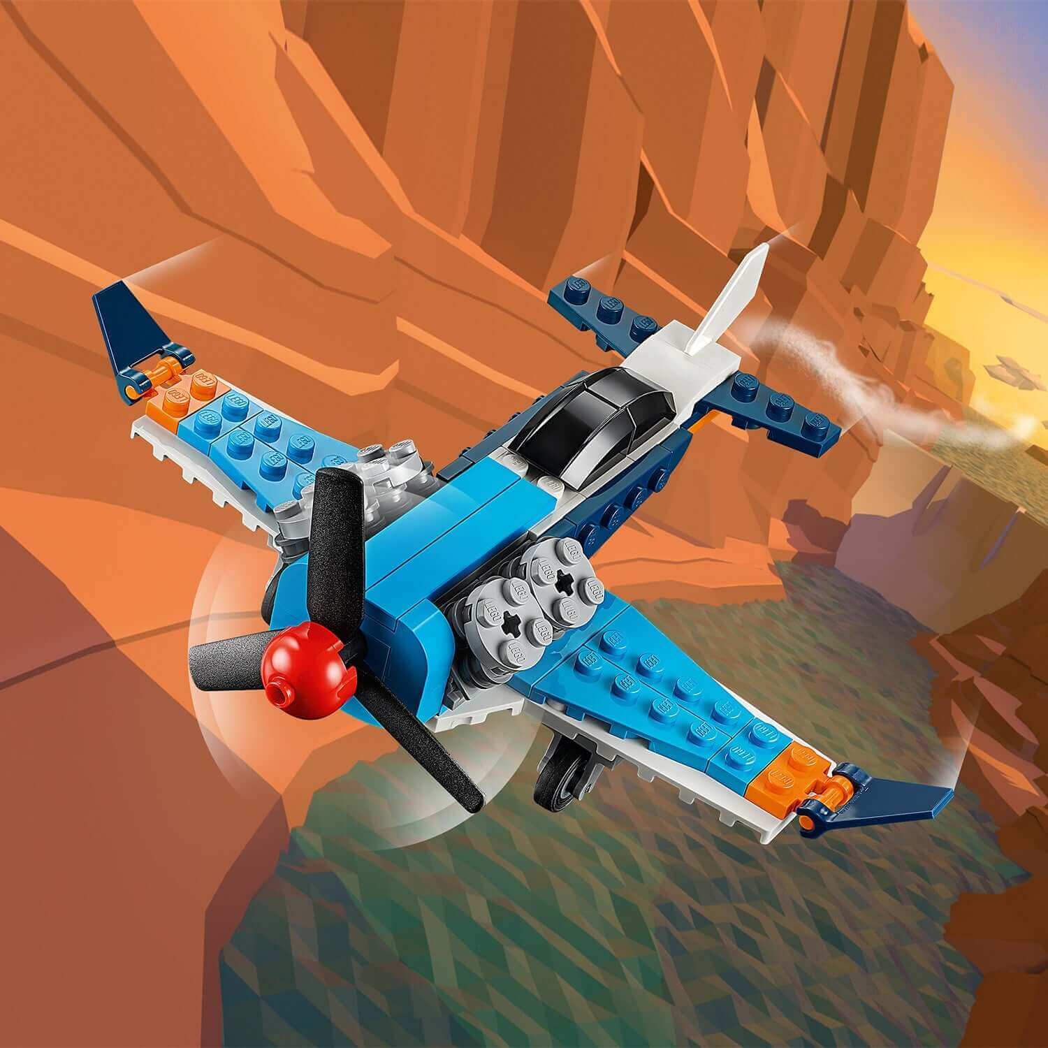 LEGO Creator 3in1 Propeller Plane Set 31099 flying near cliffs, showcasing a vibrant blue and orange design.