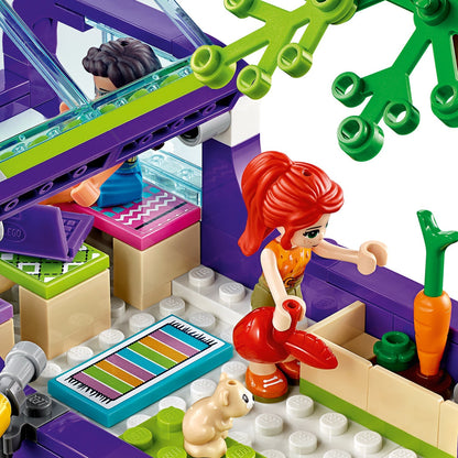 Close-up of LEGO® Friends set showing characters playing inside the Friendship Bus with colorful accessories.