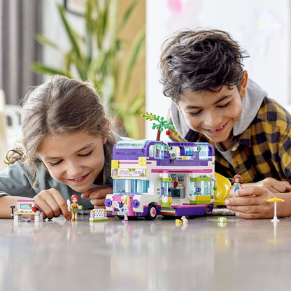Two children playing with LEGO® Friends Friendship Bus Toy 41395 featuring a swimming pool and creative accessories.