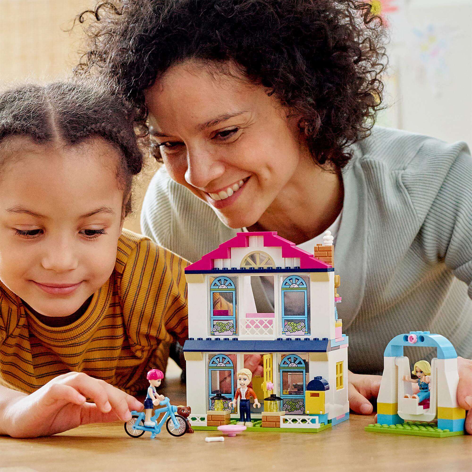 Child and parent enjoying LEGO Friends 4+ Stephanie's House Play Set with creative role-play scenes.