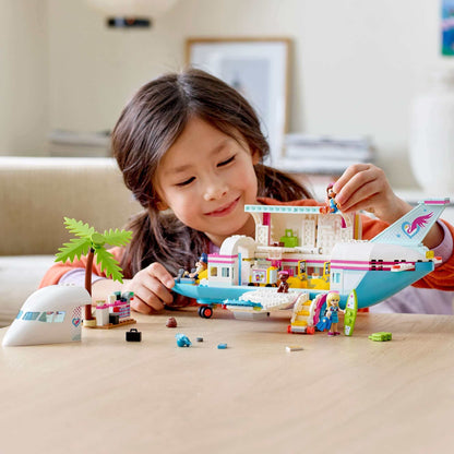 A child playing with the LEGO® Friends Heartlake City aeroplane playset, featuring characters and accessories.