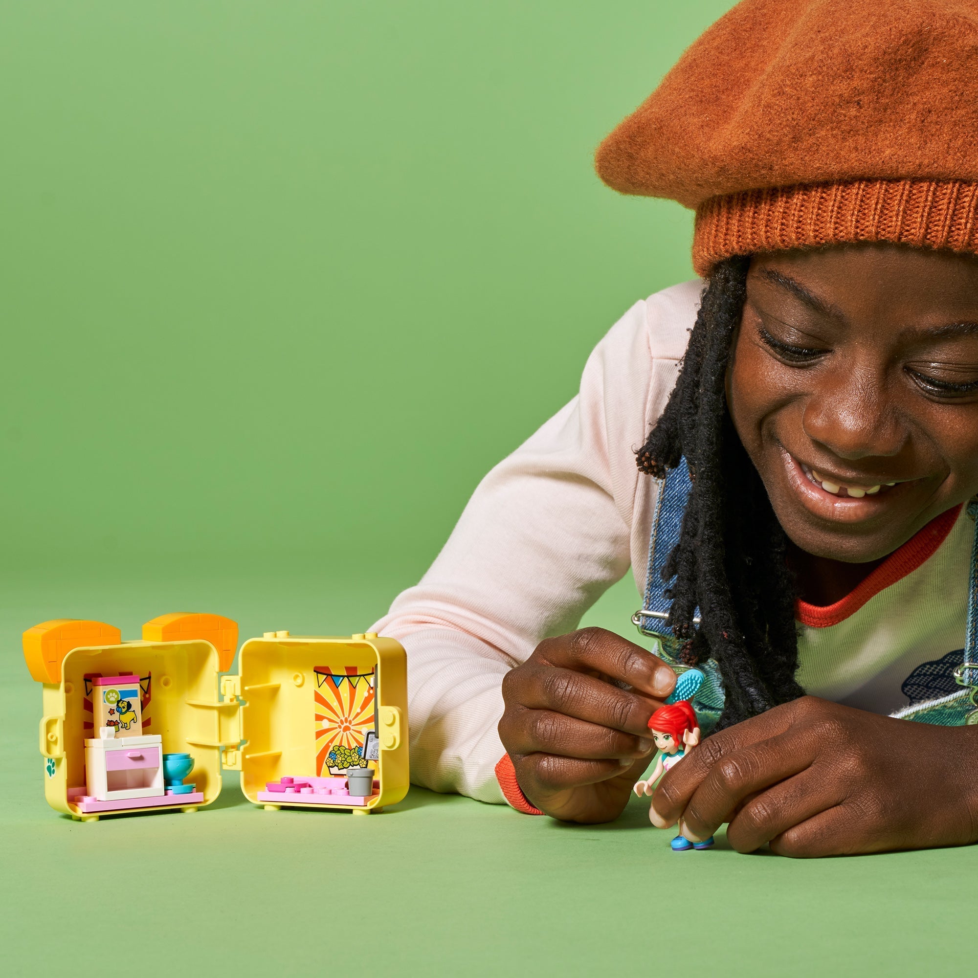 Child playing with LEGO® Friends Mia’s Pug Cube Playset 41664, showcasing colorful portable toy.