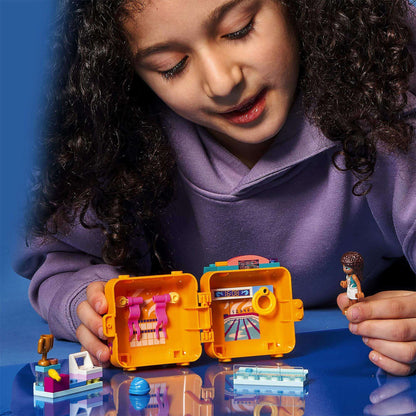 Child playing with LEGO® Friends Andrea's Swimming Cube Play Set 41671, showcasing colorful interior and mini-figure.