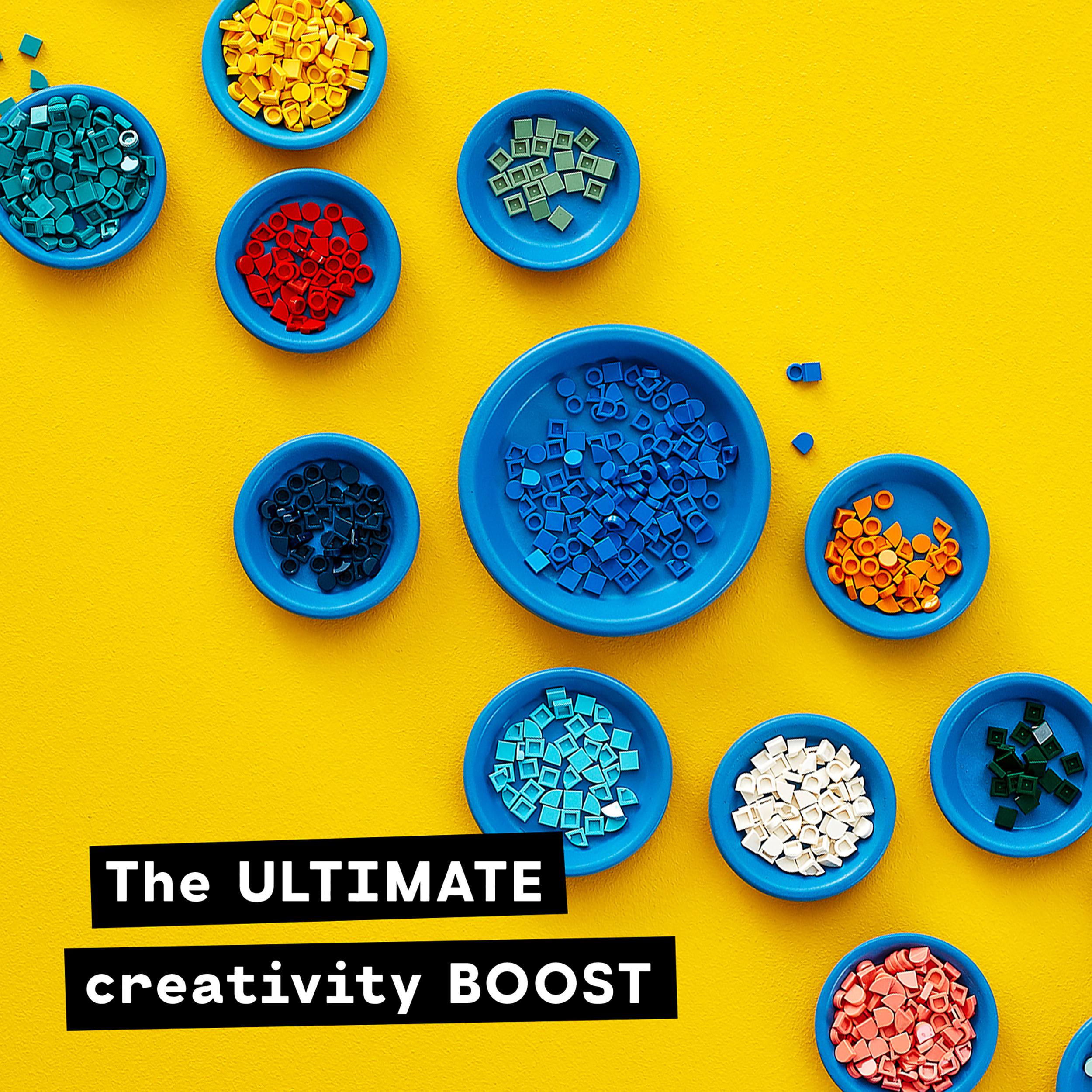 Colorful LEGO® DOTS tiles in blue bowls on a bright yellow background, perfect for creative crafting fun.