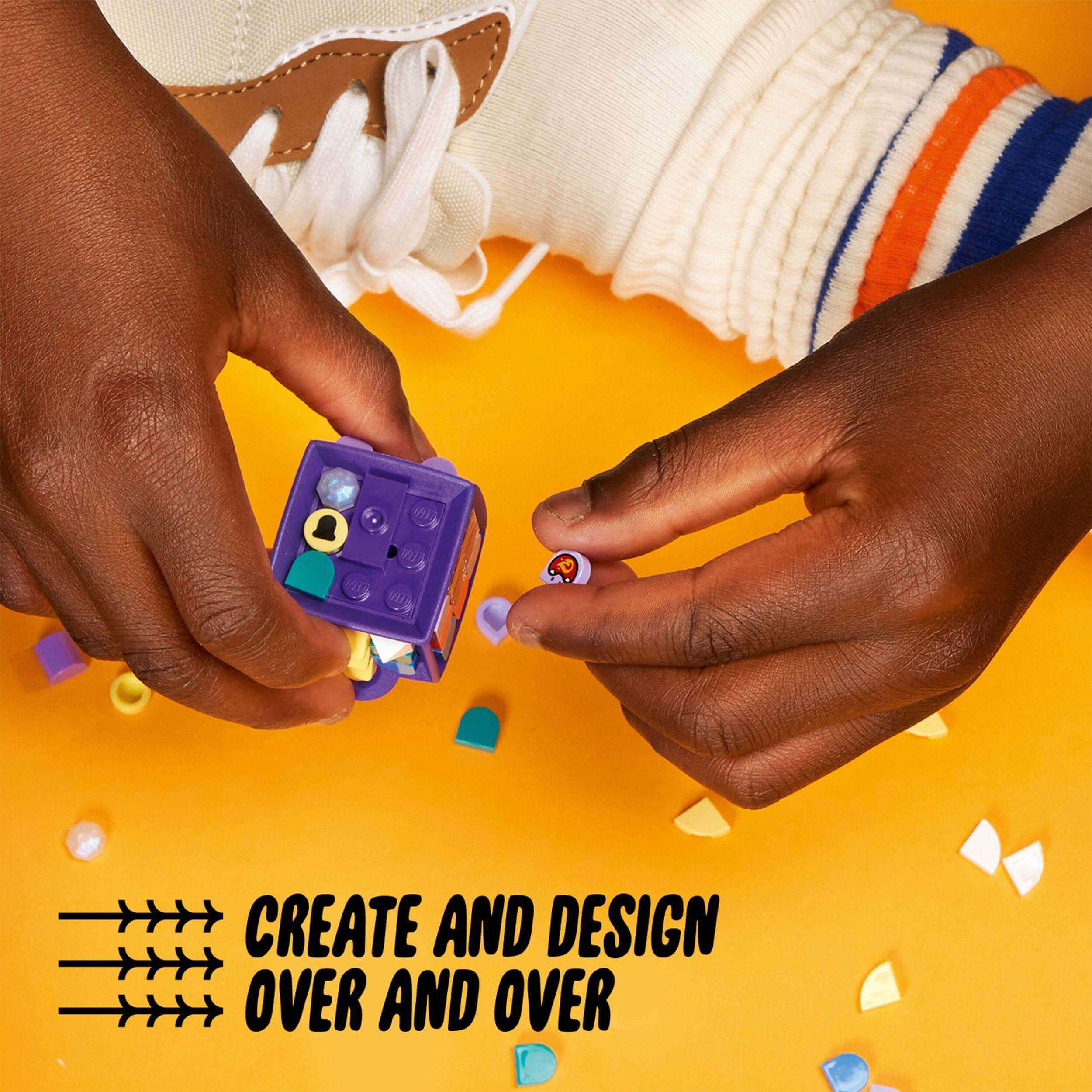 Child's hands crafting with LEGO® DOTS Bag Tag Dragon 41939, colorful tiles on a bright surface.