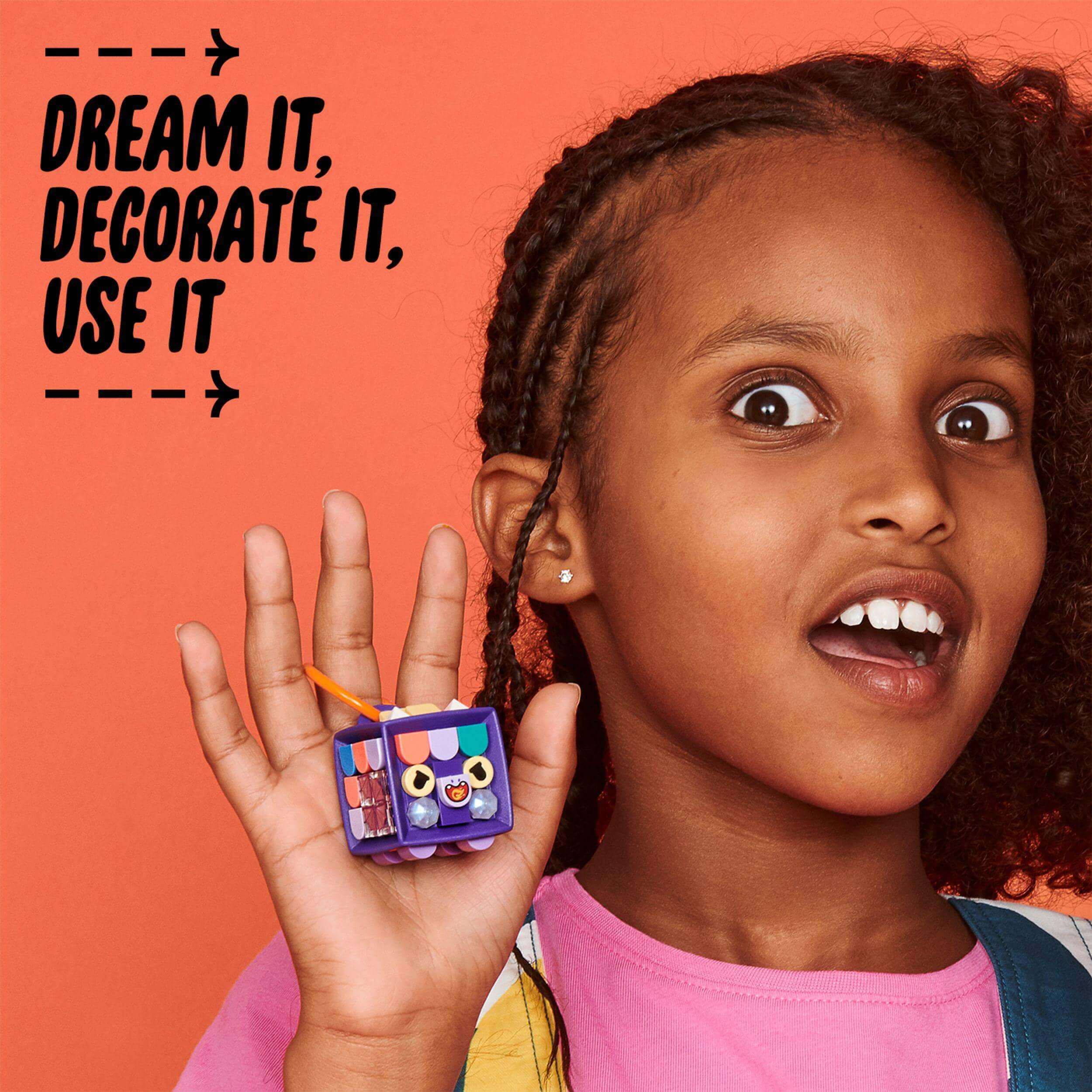 Child showcasing the LEGO® DOTS Bag Tag Dragon kit, emphasizing creativity with customizable decorations.