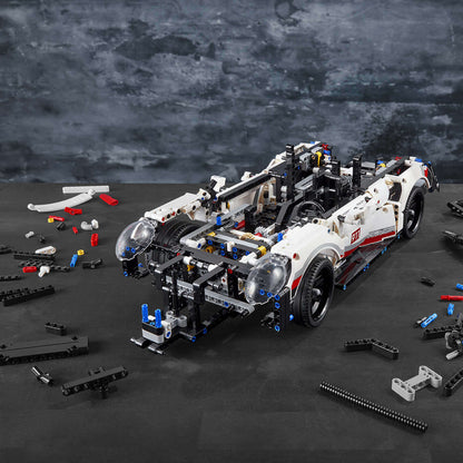 LEGO Technic Porsche 911 RSR model car set, showcasing realistic details and parts on a workspace.