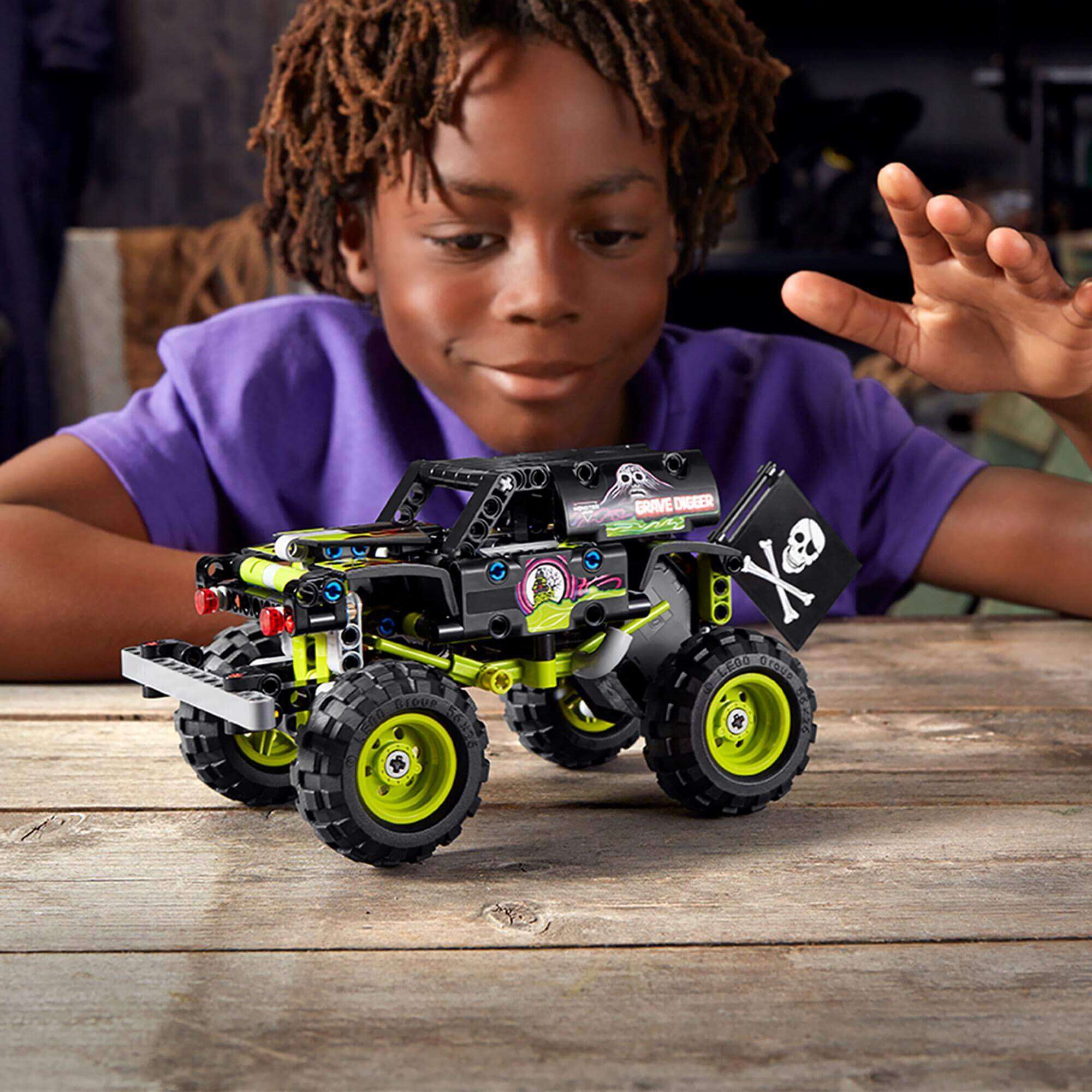Child enjoying LEGO Technic Monster Jam Grave Digger toy 42118, showcasing creativity and fun with a monster truck build.