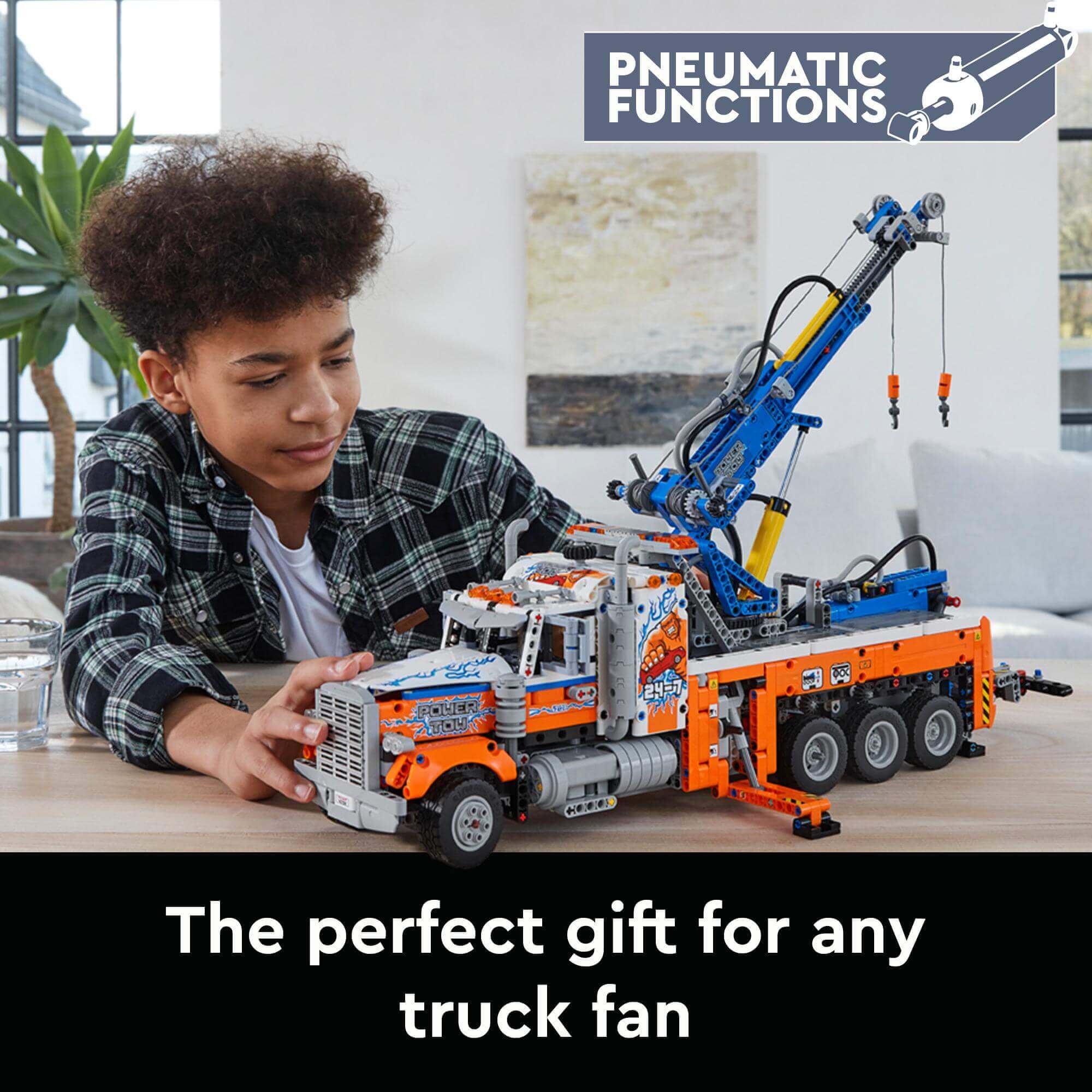 Child playing with LEGO® Technic Heavy-Duty Tow Truck 42128, showcasing authentic design and pneumatic functions.