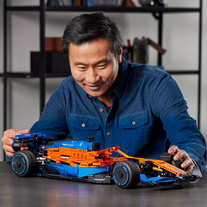 Enthusiast assembling the LEGO Technic McLaren Formula 1 Race Car model, showcasing intricate design and detail.