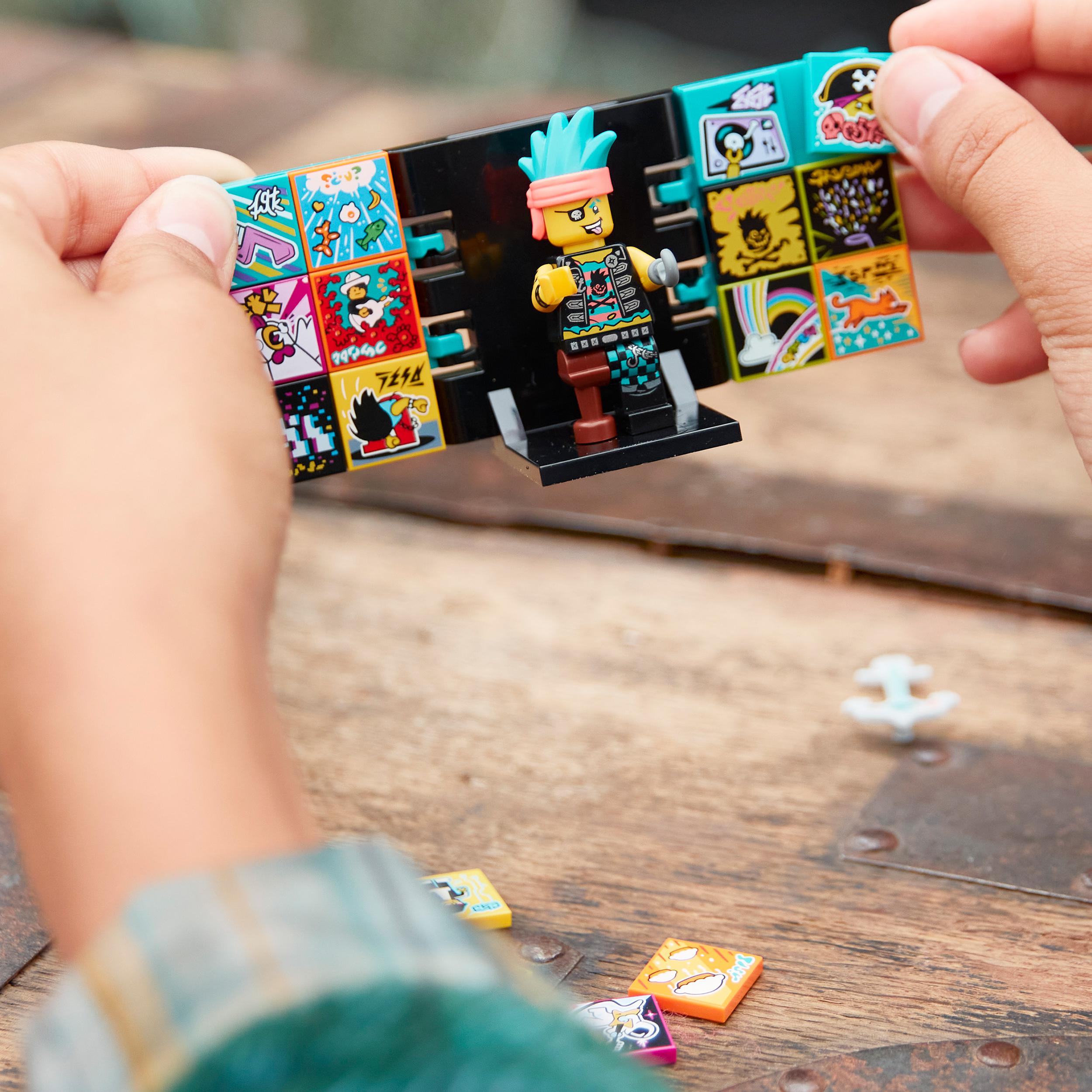 Child holding LEGO® VIDIYO Punk Pirate BeatBox with colorful tiles and a punk pirate character for music video creation.