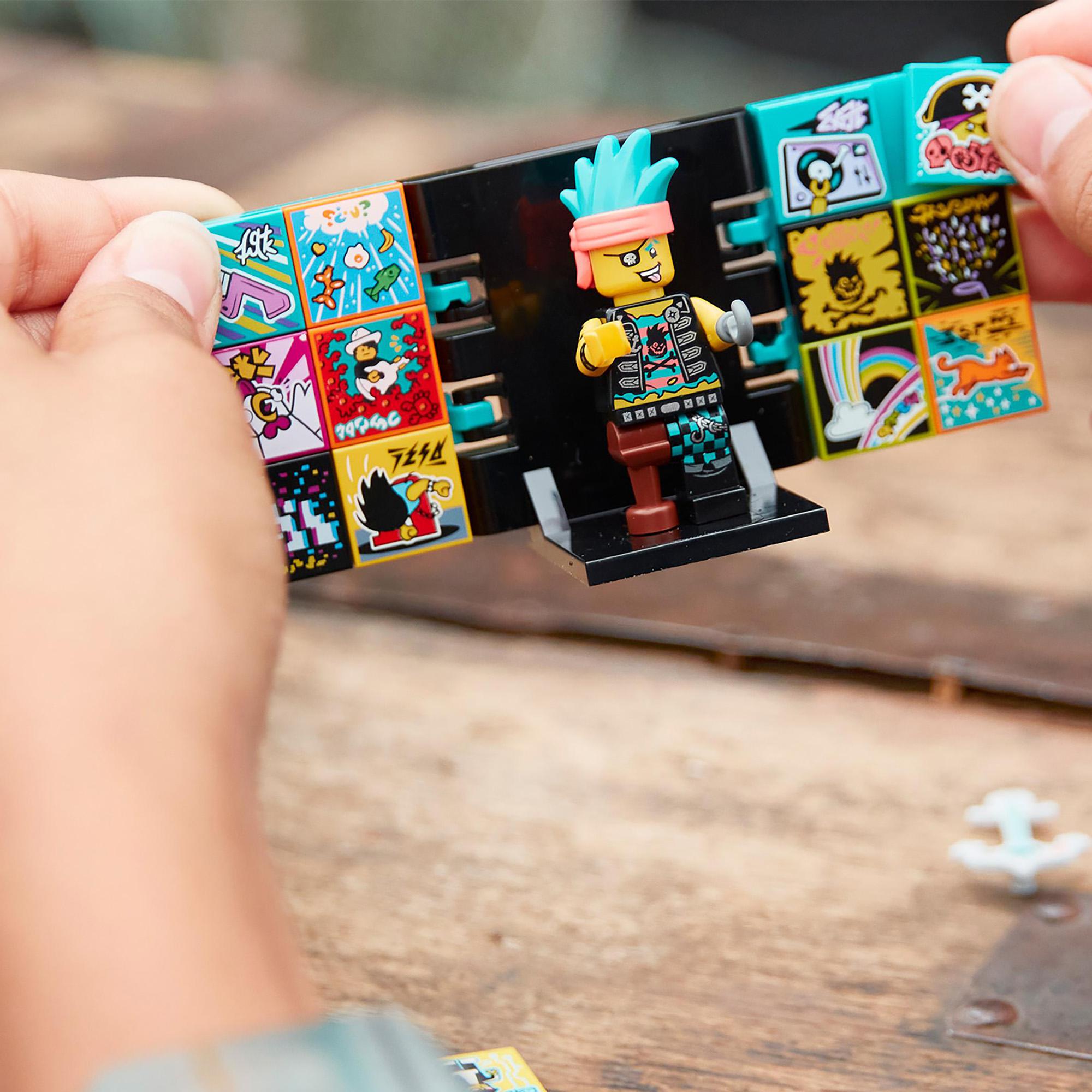 Child holding LEGO VIDIYO Punk Pirate BeatBox with colorful tiles and a punk character on a table.