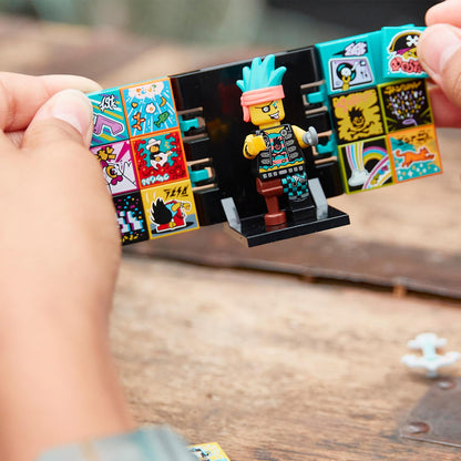 Child holding LEGO VIDIYO Punk Pirate BeatBox with colorful tiles and a punk character on a table.