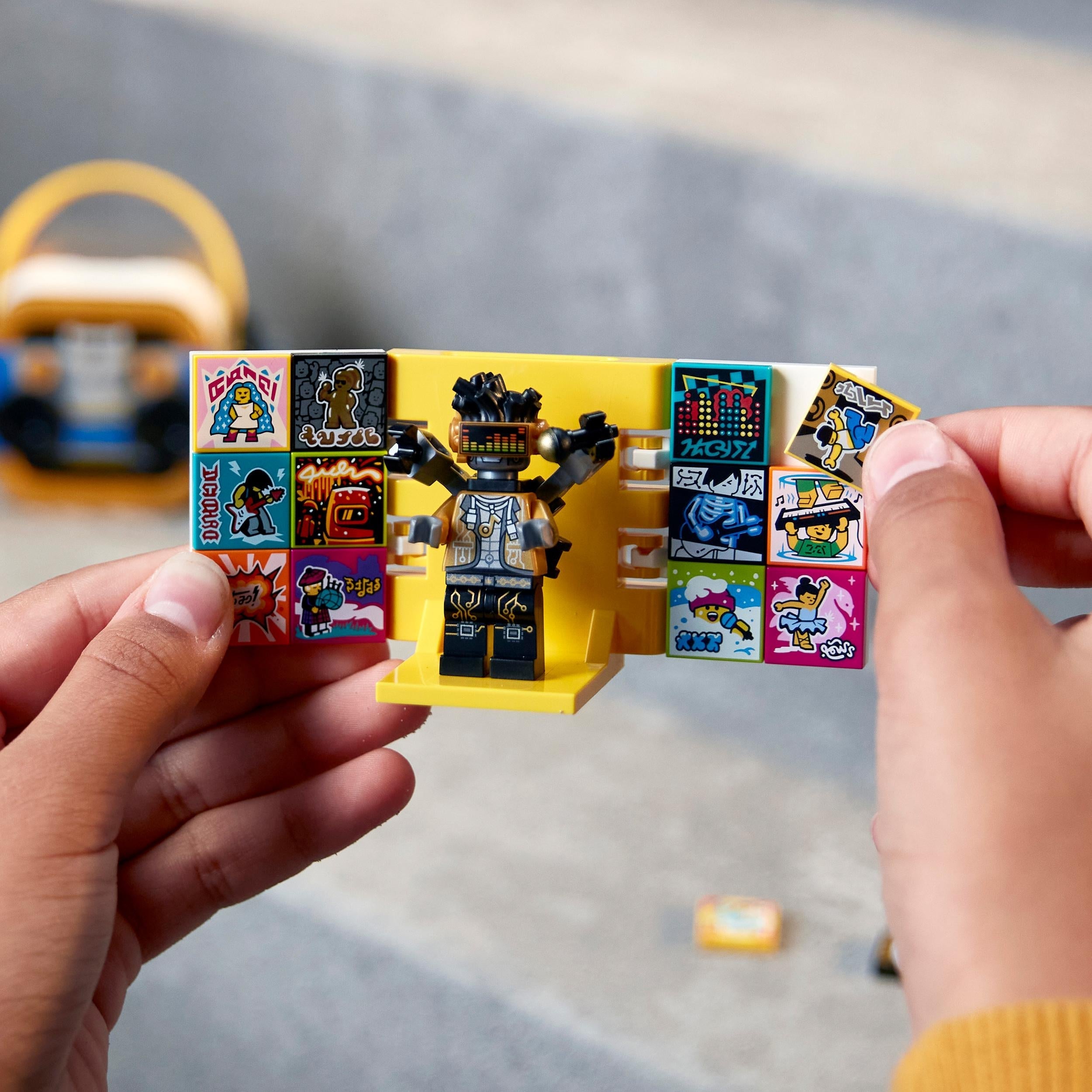 Child holding LEGO® VIDIYO HipHop Robot BeatBox set with stickers and figure, perfect for creative music video production.
