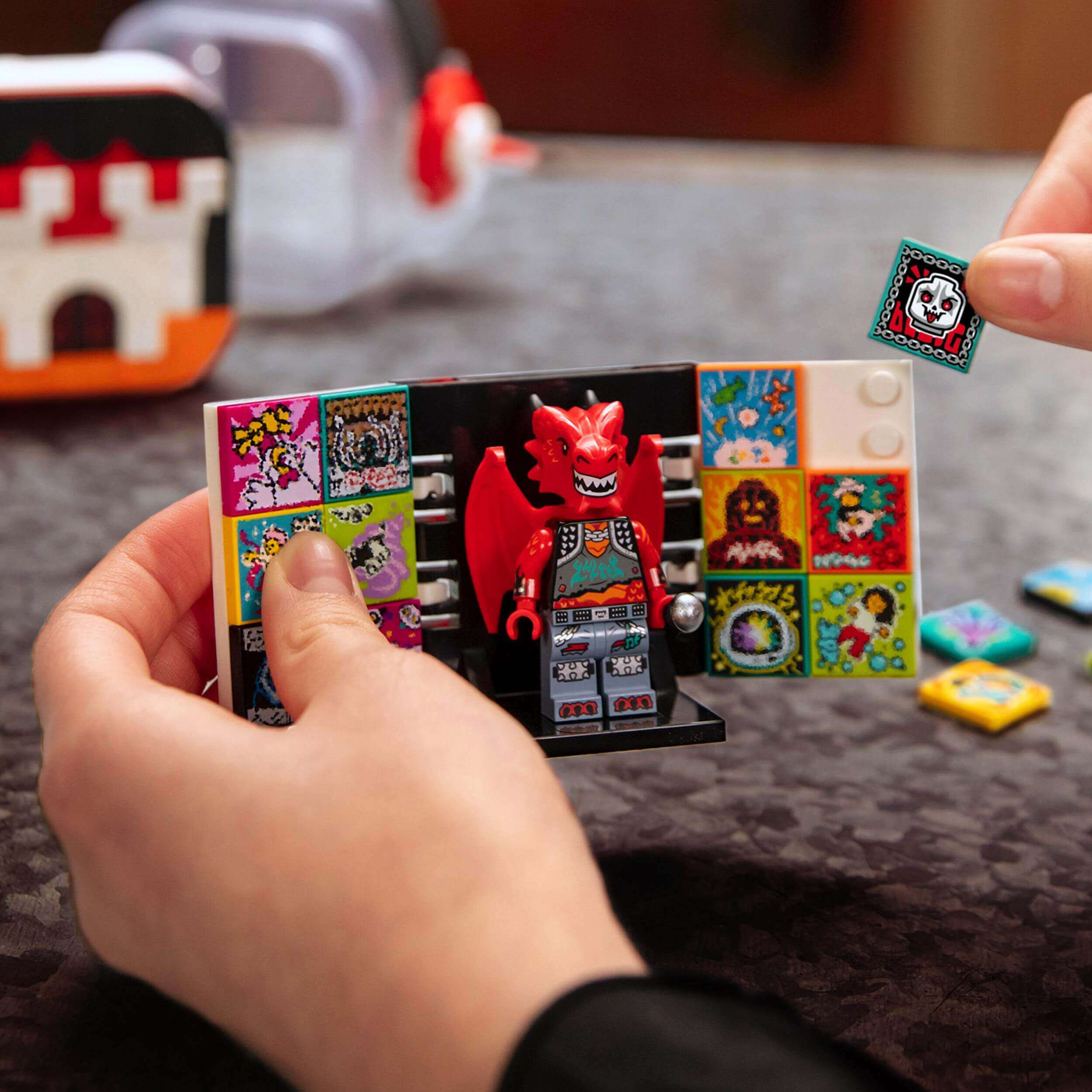 Child assembling LEGO® VIDIYO Metal Dragon BeatBox set with colorful tiles and dragon figurine for creative music videos.