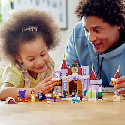 Child and adult enjoying LEGO Disney Princess Belle's Castle Winter Toy set with characters and colorful castle.