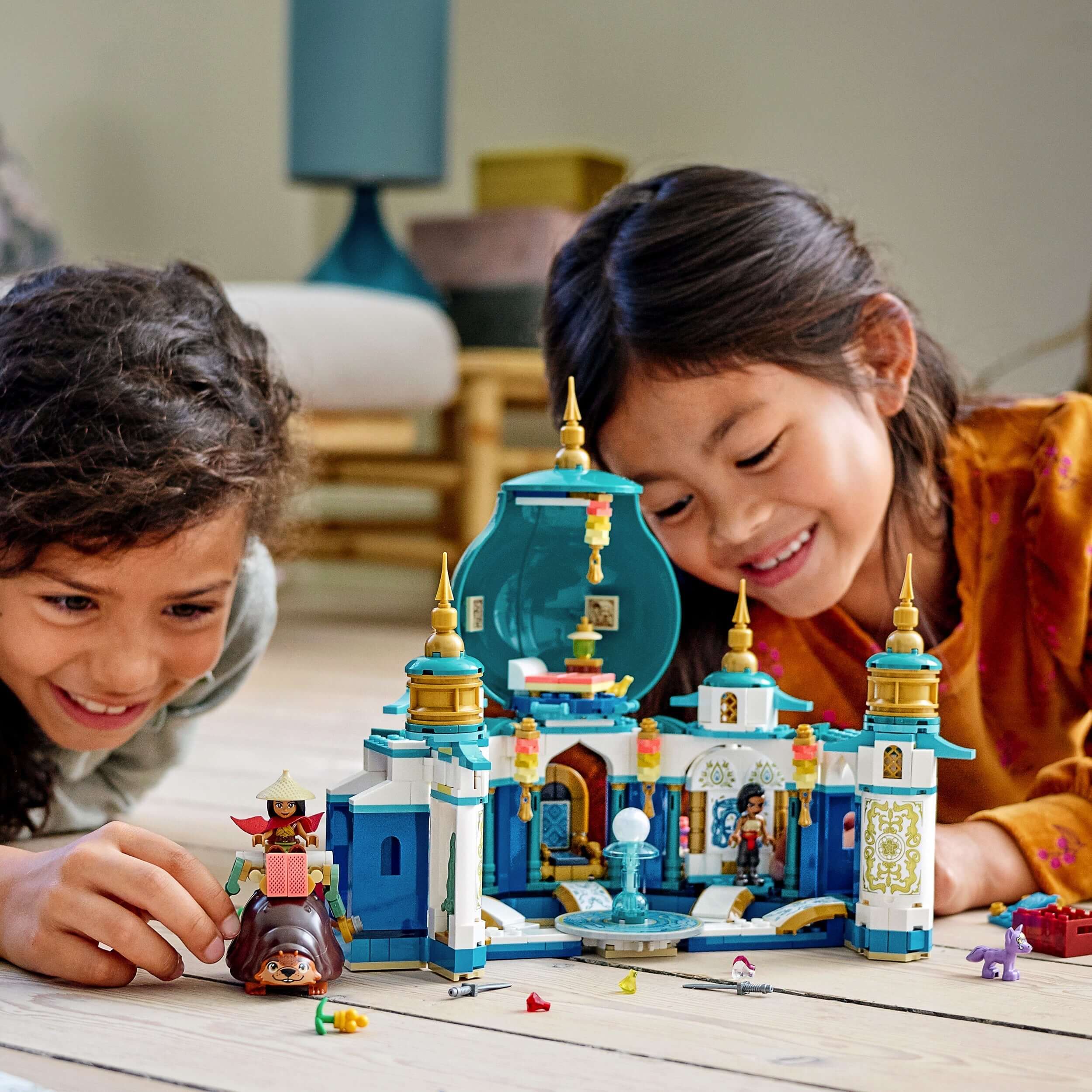 Kids playing with LEGO® Disney Raya and the Heart Palace Playset 43181 featuring minidolls and Tuk Tuk.
