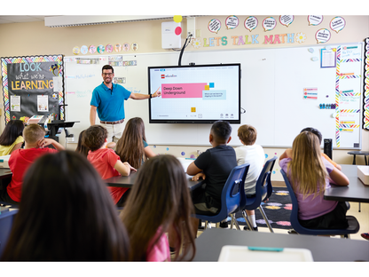 Teacher engaging students in a classroom using interactive technology for hands-on learning.