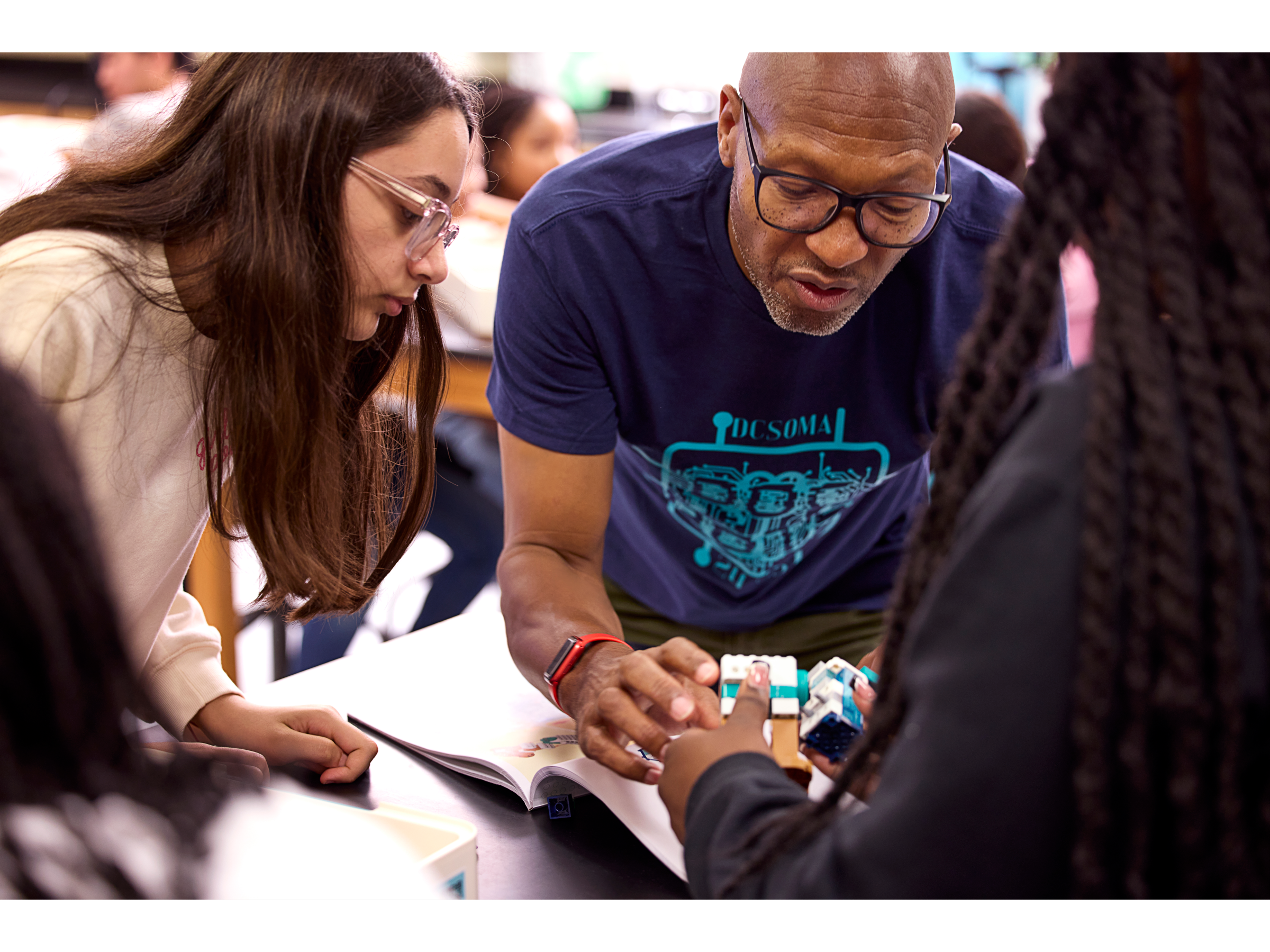 Students collaborating with a teacher using LEGO® Education Science kits in a classroom setting.