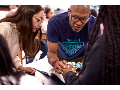 Students collaborating with a teacher using LEGO® Education Science kits in a classroom setting.