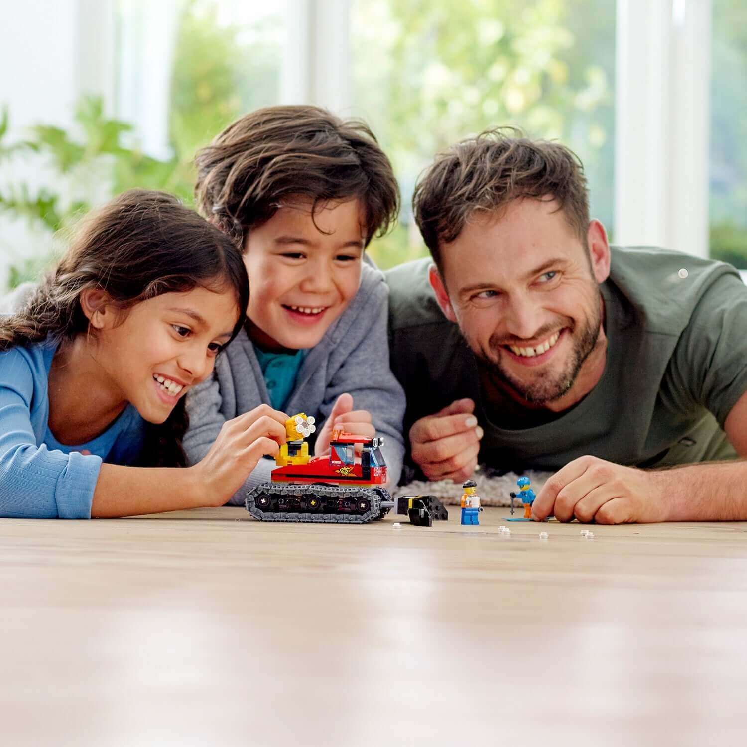 Family enjoying the LEGO® City Snow Groomer with Plough Toy 60222 while building and playing together.