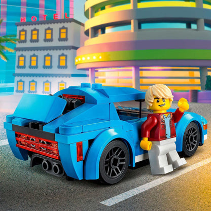LEGO City Sports Car 60285 with minifigure driver in vibrant city scene, featuring a removable roof and sporty rims.