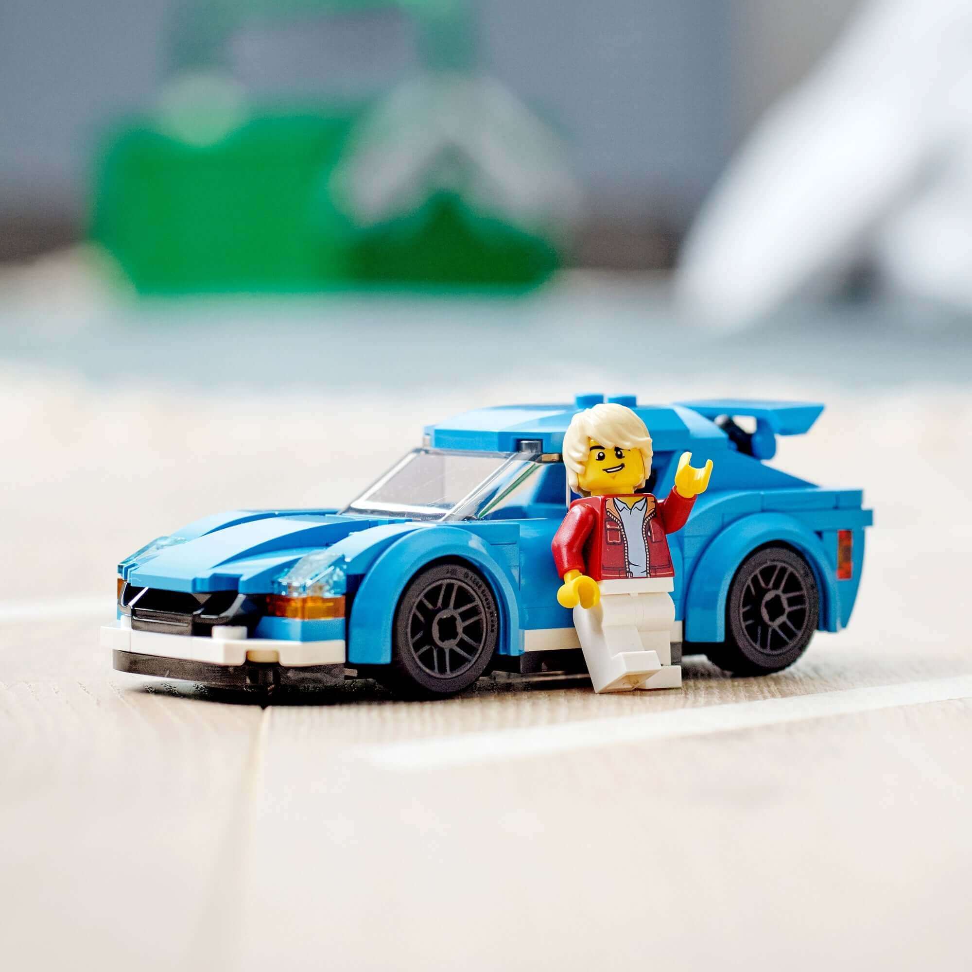 LEGO® City Sports Car Toy 60285 with minifigure driver, blue color, and sporty design on a wooden surface.