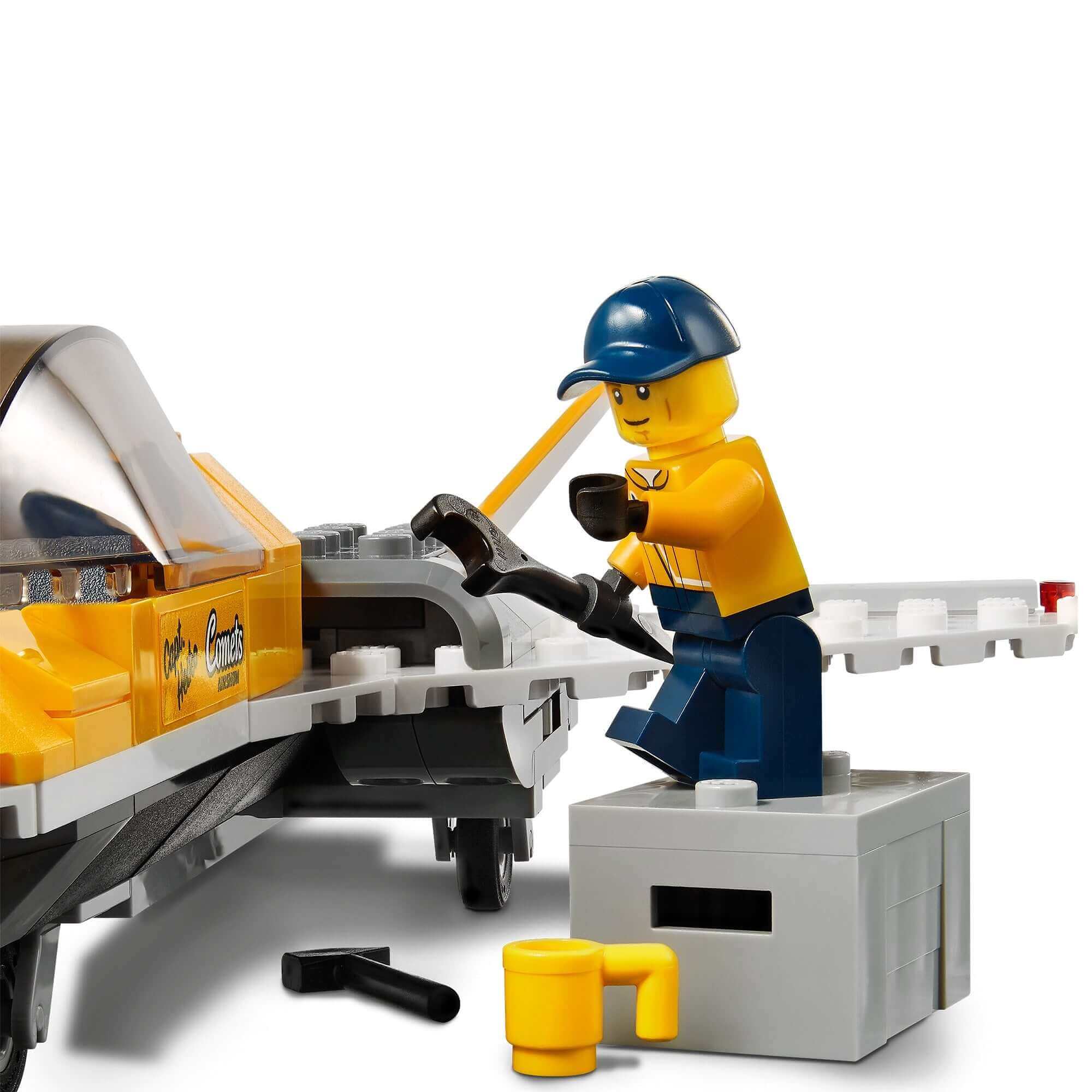 LEGO City Airshow minifigure fixing a yellow jet with tools beside it, highlighting creativity in play.