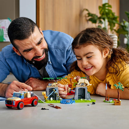 Father and daughter enjoying LEGO City Wildlife Rescue Off Roader playset with animals and adventure scenery.