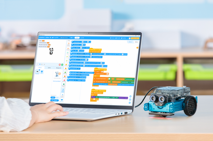 Student programming Makeblock mBot 2 robot using a laptop with coding interface.