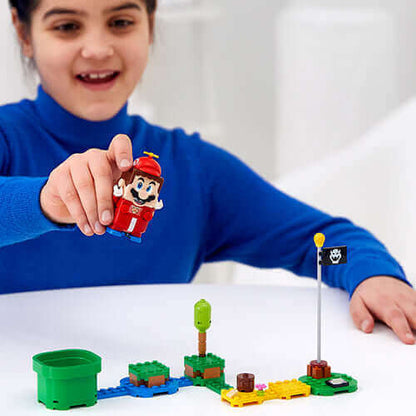 Child playing with LEGO® Super Mario™ figure and interactive blocks, creating a fun game scene.