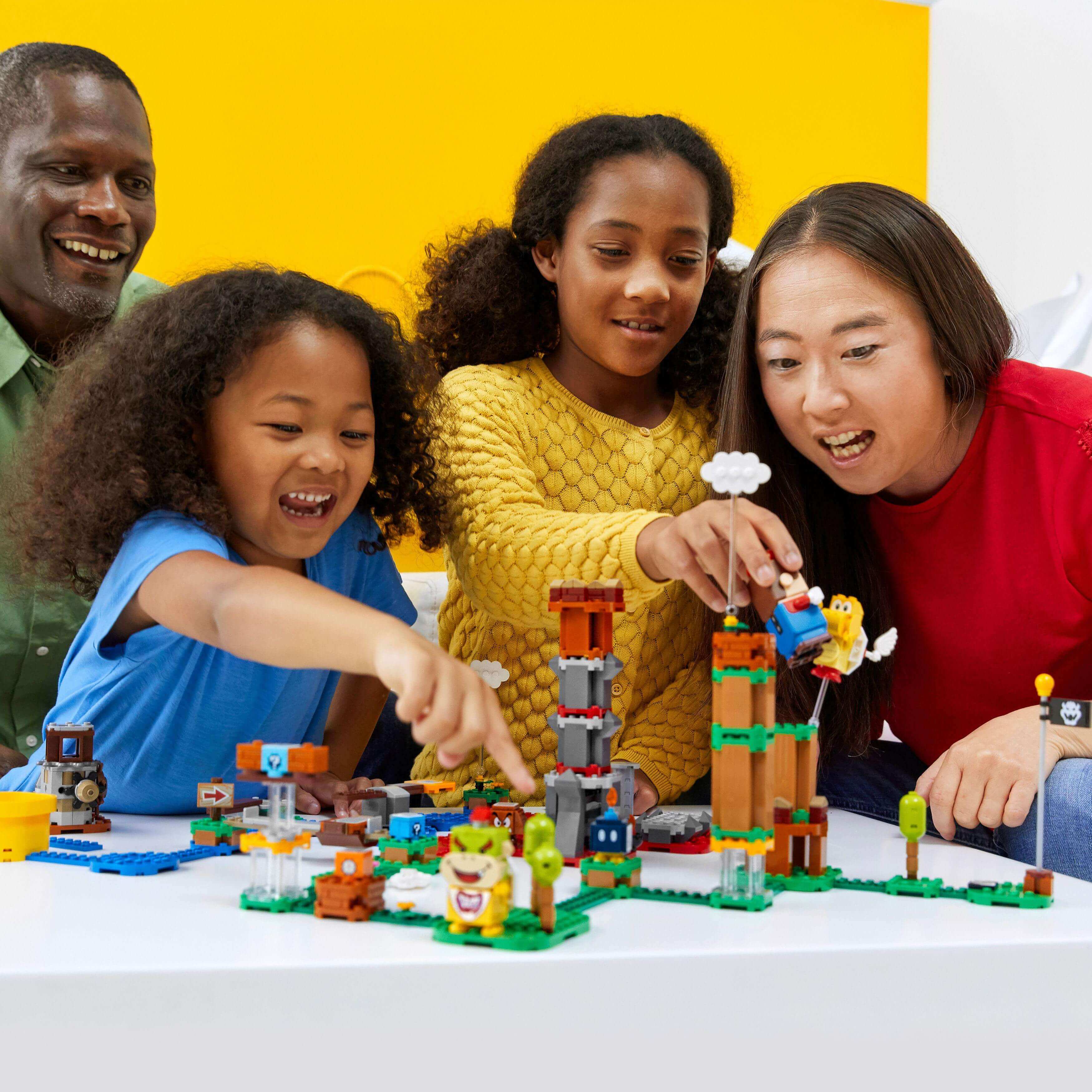 Family enjoying the LEGO® Super Mario Master Adventure Maker Set 71380, creating unique levels and having fun together.
