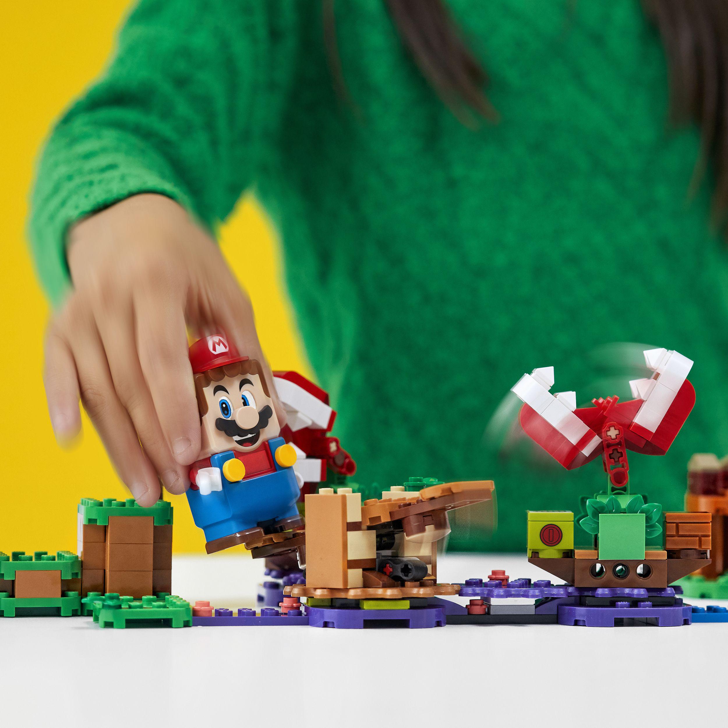 Child playing with LEGO® Super Mario Piranha Plant Expansion Set 71382, featuring Mario and Piranha Plants in action.