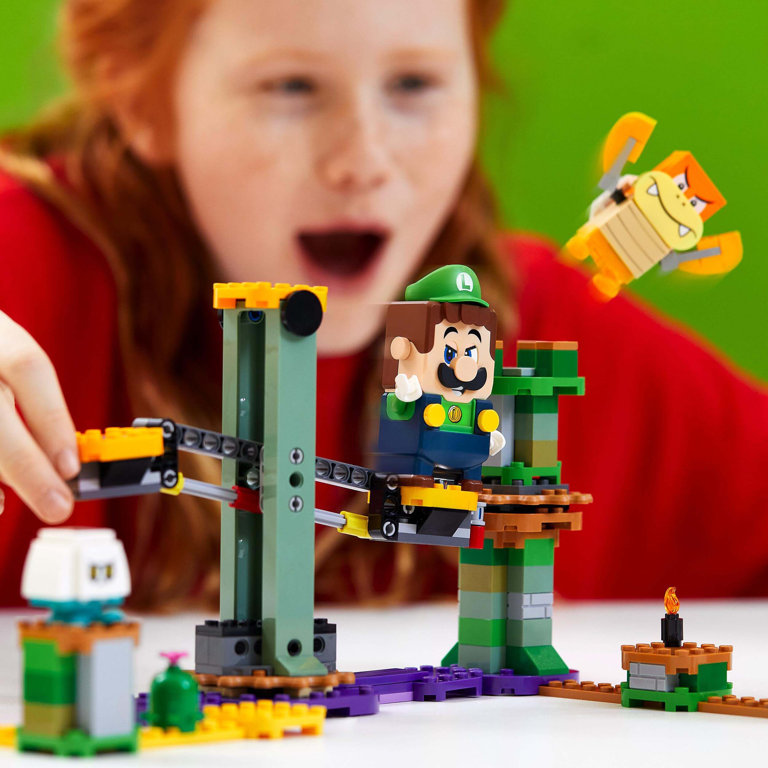 Child playing with LEGO® Super Mario Luigi Starter Course, featuring interactive Luigi figure and buildable scenes.