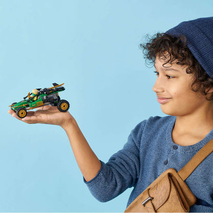 Child holding LEGO® NINJAGO Legacy Jungle Raider Set 71700, featuring Lloyd ready for battle.