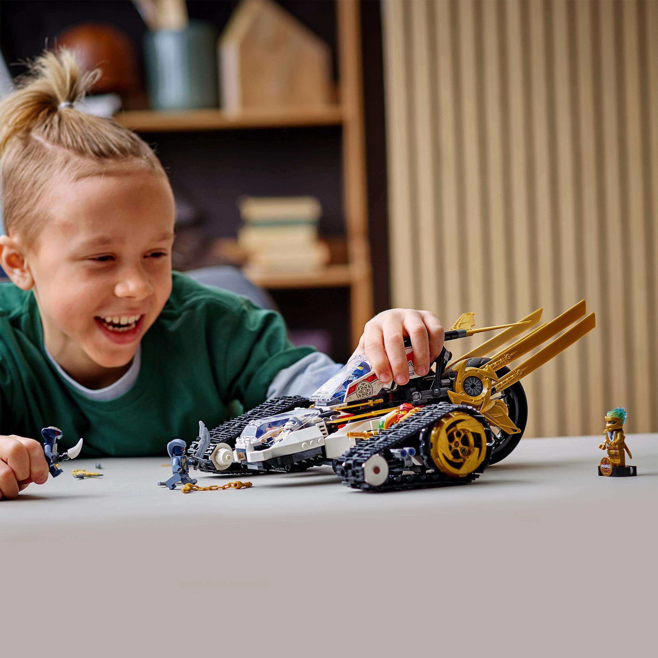 Child playing with LEGO® NINJAGO Ultra Sonic Raider Set 71739, showcasing a 4-in-1 vehicle with joy and creativity.