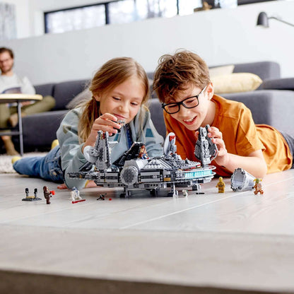 Two children playing with the LEGO® Star Wars Millennium Falcon Set 75257, surrounded by Star Wars figurines on the floor.