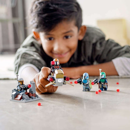 Child playing with LEGO® Star Wars Mandalorian Battle Pack set 75267, featuring minifigures, speeder, and defense fort.
