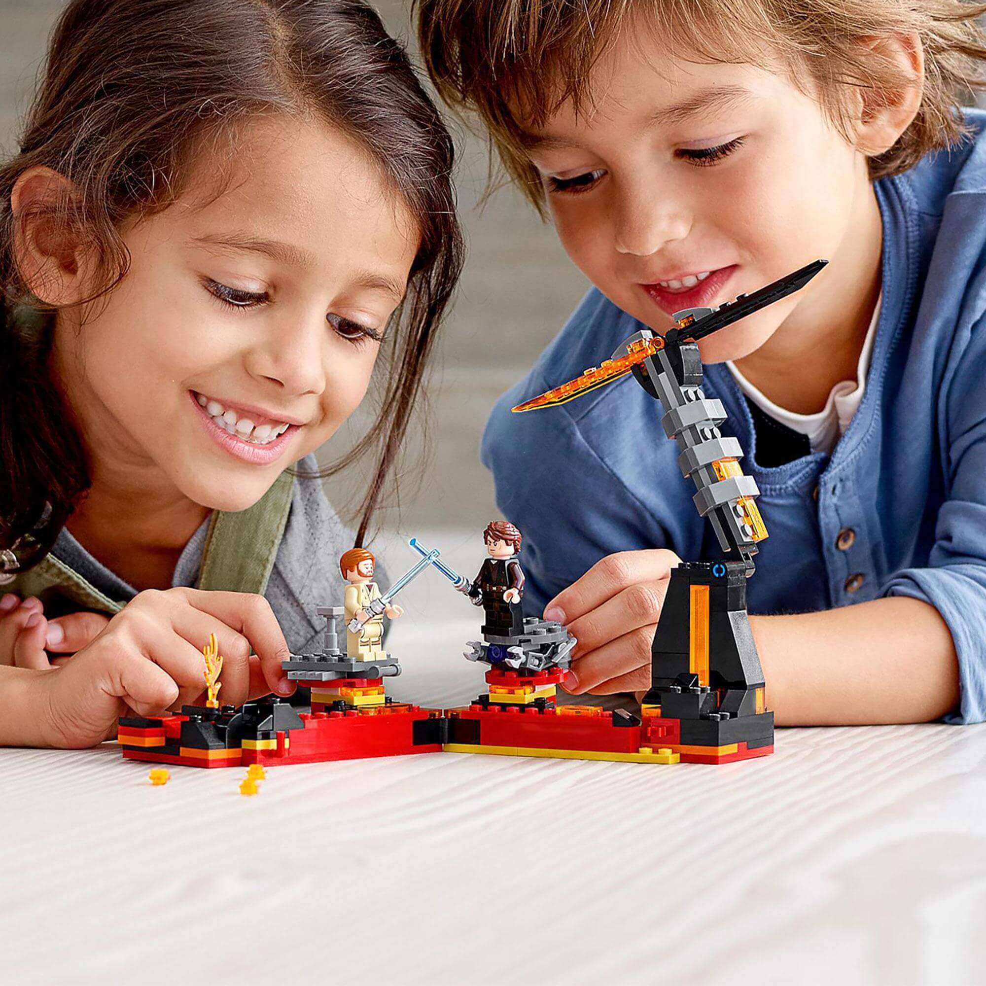 Children playing with LEGO® Star Wars Duel on Mustafar set, featuring Obi-Wan and Anakin in a lightsaber battle.