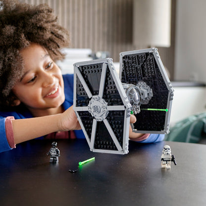 Child playing with LEGO® Star Wars Imperial TIE Fighter Toy 75300, featuring minifigures and lightsaber.
