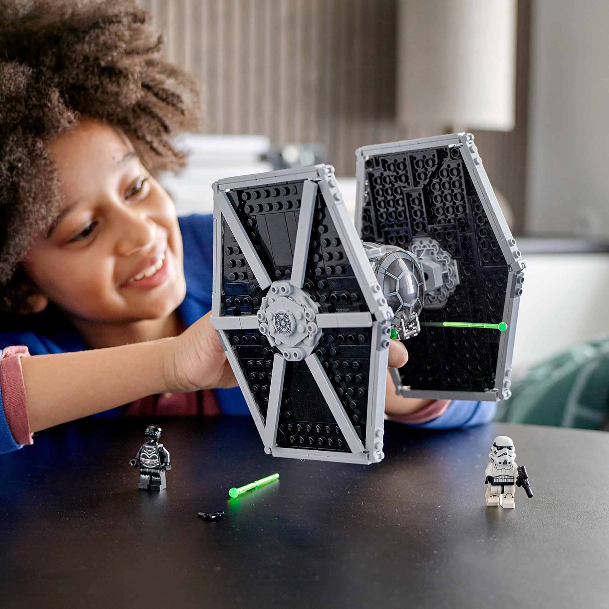 Child playing with LEGO® Star Wars Imperial TIE Fighter Toy 75300, featuring TIE Fighter and minifigures.