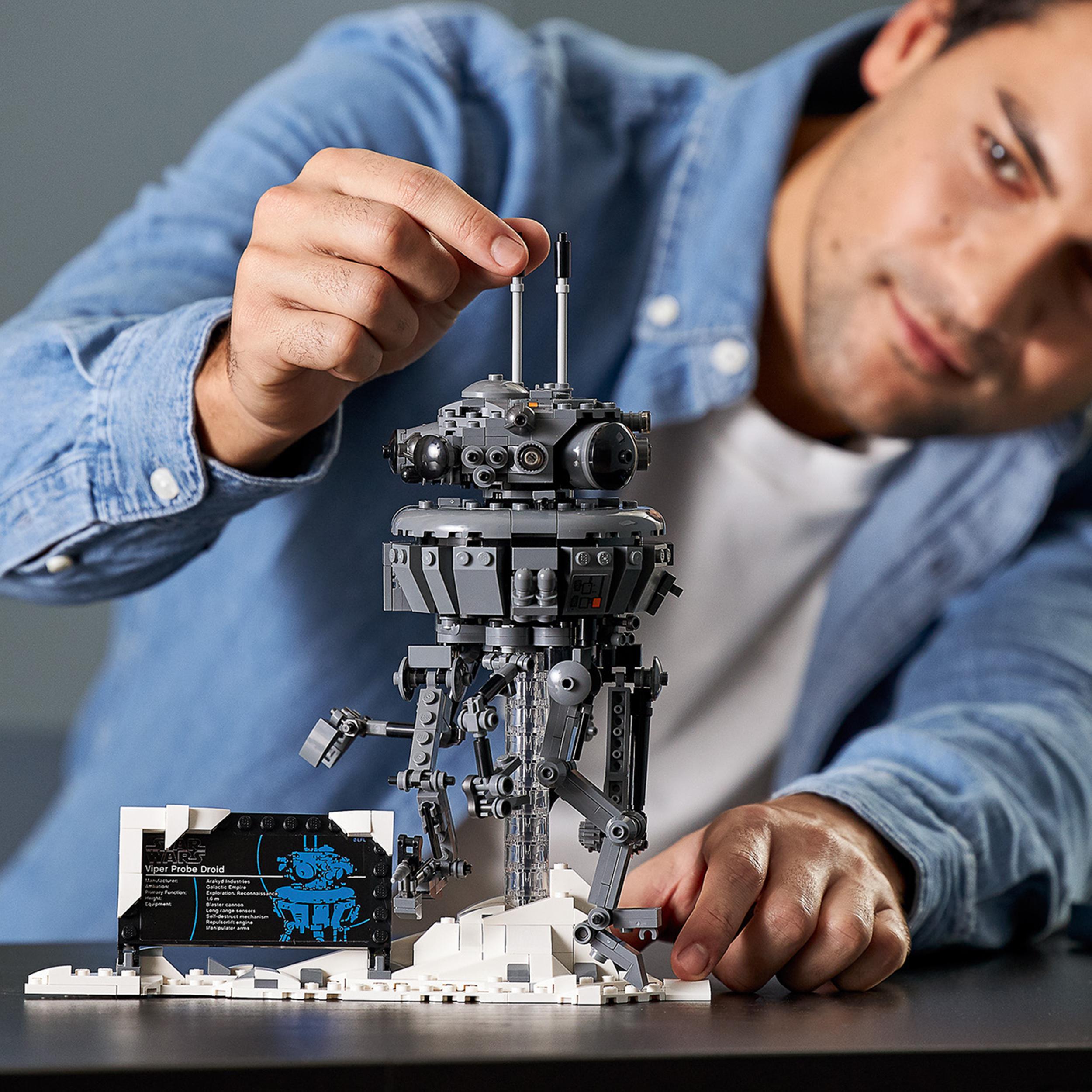 Adult builds LEGO® Star Wars Imperial Probe Droid 75306 in a snowy Hoth scene, showcasing intricate details.