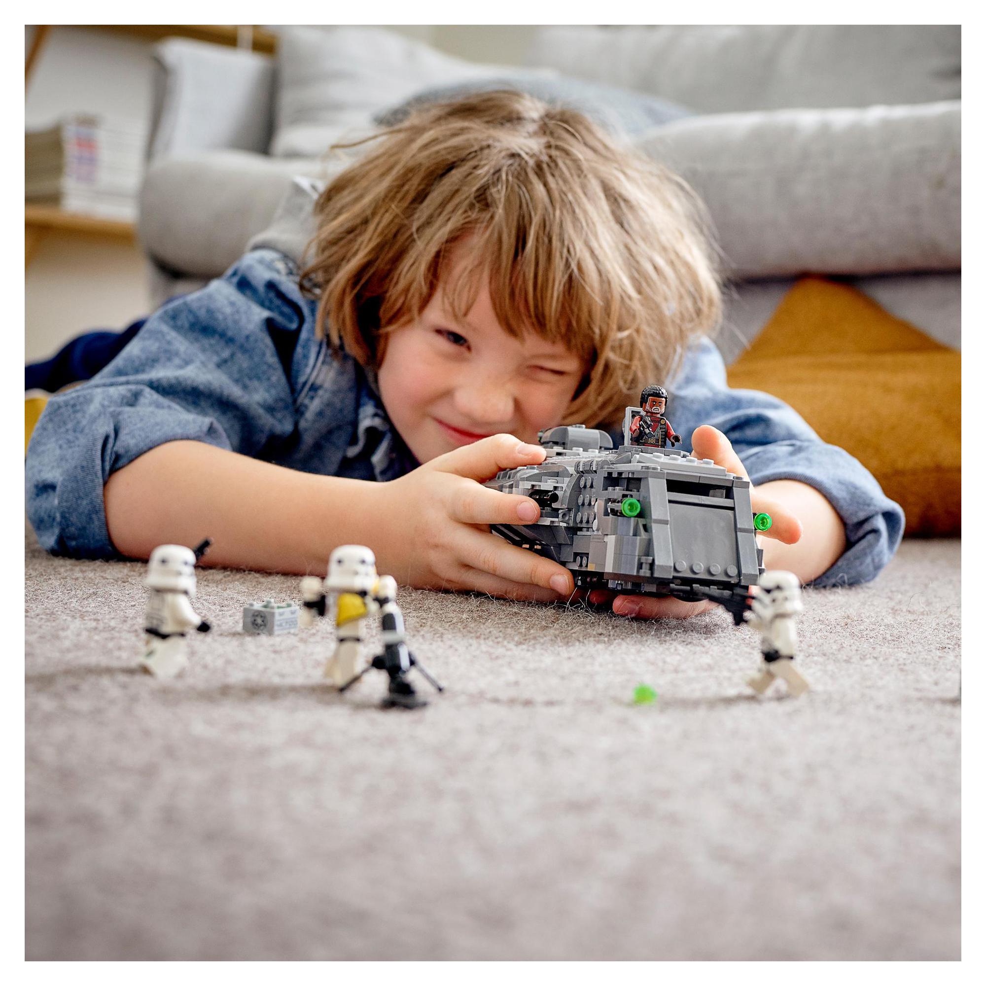 Child playing with LEGO Star Wars Imperial Armoured Marauder set 75311, recreating battles with Stormtroopers.