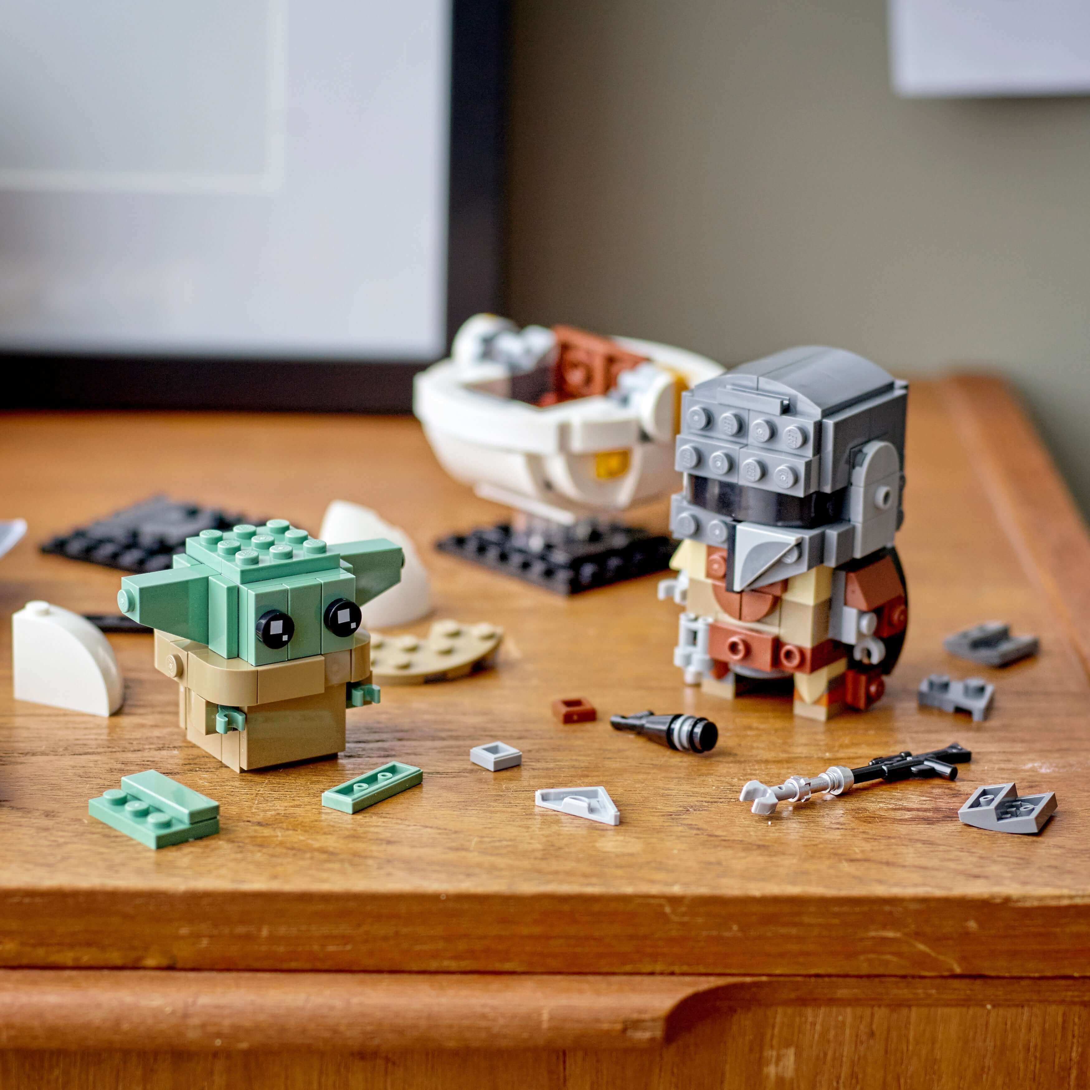 LEGO® BrickHeadz Star Wars The Mandalorian 75317 set featuring The Mandalorian and the Child, with building pieces on a table.